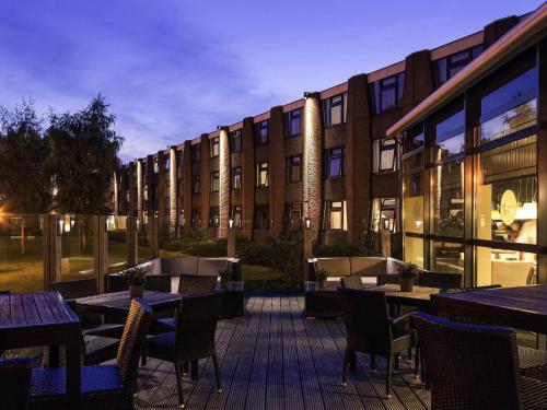 un patio esterno con tavoli e sedie di fronte a un edificio di Mercure Hotel Amsterdam West ad Amsterdam