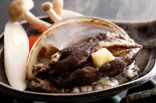 a piece of meat in a pan with a stick of butter at Sennentei in Yurihama