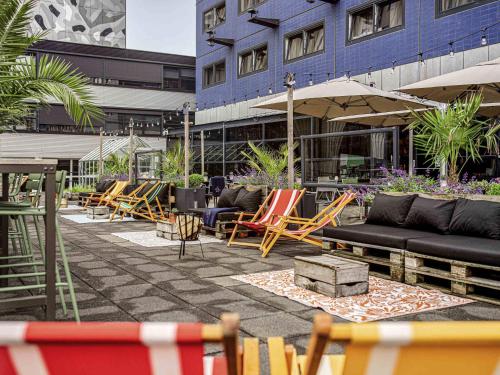 a patio with a bunch of chairs and furniture at Mercure Hotel Den Haag Central in The Hague