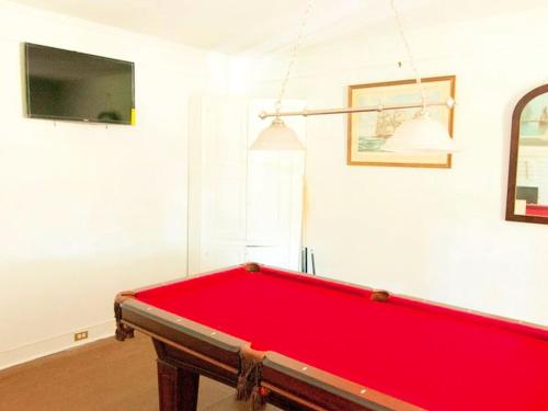 a red pool table in a room with a tv at Family-Friendly Waterfront Getaway with a Swimming Pool and Dock in Cambridge, Maryland in Cambridge