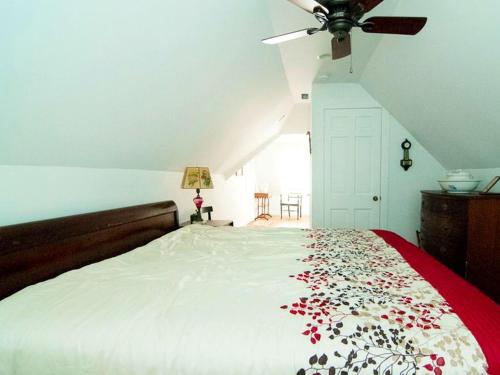 a bedroom with a bed with a red blanket with flowers on it at Family-Friendly Waterfront Getaway with a Swimming Pool and Dock in Cambridge, Maryland in Cambridge