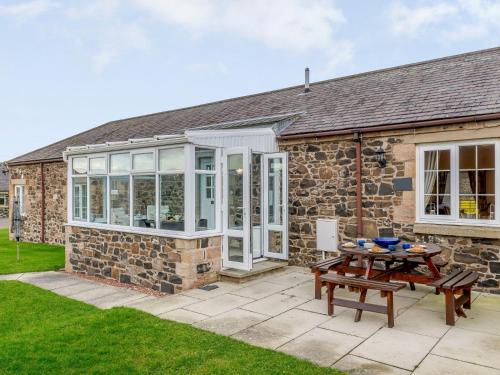 a stone house with a patio and a table at 2 Bed in Newton-by-the-Sea 80485 in Newton by the Sea