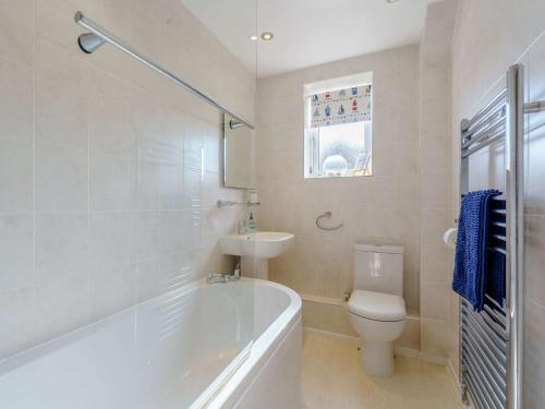 a bathroom with a tub and a toilet and a sink at 2 bed in Totland Bay IC003 in Freshwater