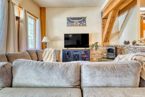 ein Wohnzimmer mit Sofa und Fernseher in der Unterkunft Idyllic Cozy Cabin Haven near Whistle Lake in Washington in Anacortes