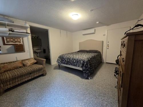 ein Schlafzimmer mit einem Bett und einer Couch in der Unterkunft Waterfront Vacation Rental for Two Guests near Ohiopyle State Park, Pennsylvania in Confluence