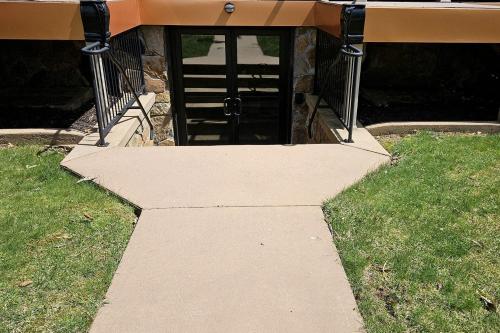 ein Gehweg, der zu einer Tür in einem Gebäude führt in der Unterkunft Waterfront Vacation Rental for Two Guests near Ohiopyle State Park, Pennsylvania in Confluence