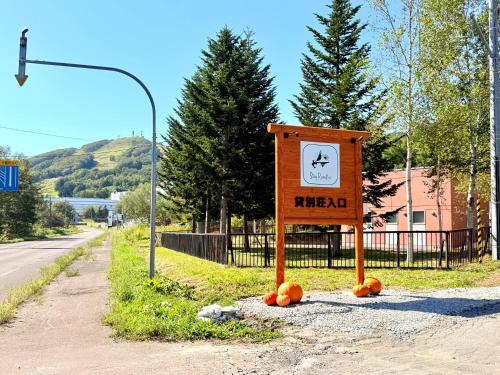 a sign on the side of a road with pumpkins in front at Yuki Usagi - walking distance to Rusutsu Resort in Rusutsu