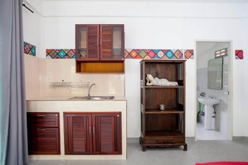 a kitchen with wooden cabinets and a sink at Villa with private pool and mountain views in Ban Khlong Son