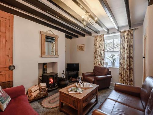 a living room with a couch and a wood stove at 2 Bed in Aberdovey 80399 in Llwyngwril