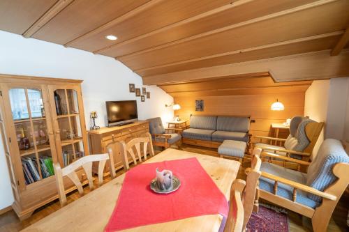 a living room with a table and a living room with a couch at Försterhaus & Haus Andrea in Mayrhofen