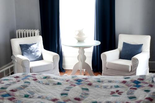 a bedroom with two chairs and a bed and a table at Elegant Bed and Breakfast on a Working Sheep Farm near Nockamixon State Park, Pennsylvania in Buckingham