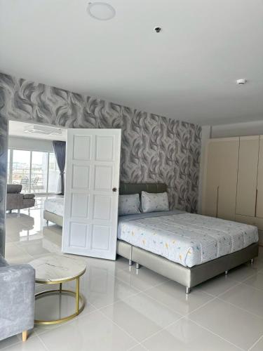 a bedroom with a bed and a couch and a table at View Talay6 by Blue Ocean Suite in Pattaya Central