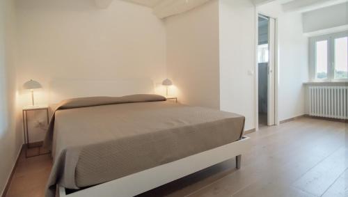 een slaapkamer met een bed in een witte kamer bij Casa Vacanze - Il Gelso in Collevecchio