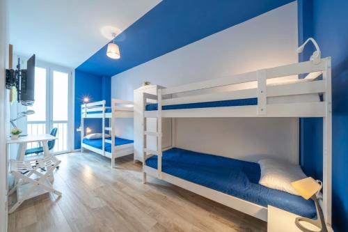 a bedroom with two bunk beds and a blue wall at LAKE COMO - 2min to Lake and Station - Free Park and Wifi in Lecco