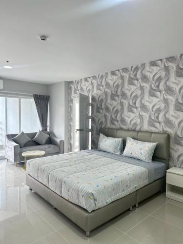 a bedroom with a large bed and a couch at View Talay6 by Blue Ocean Suite in Pattaya Central