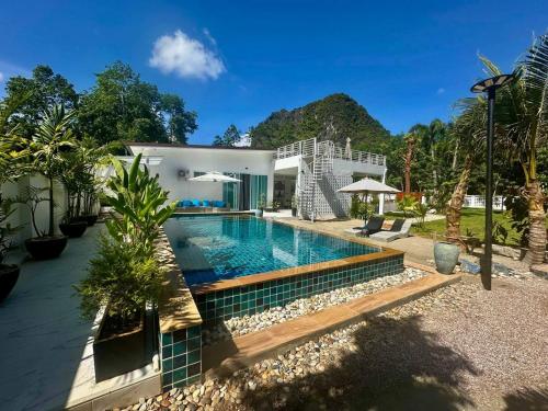 a swimming pool in front of a house at Baan Suan pool valley Villa in Ban Nong Thale