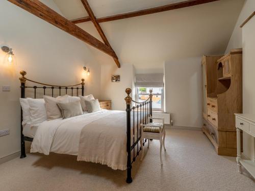 a bedroom with a large bed and a chair at 4 bed in Crickhowell 85242 in Crickhowell