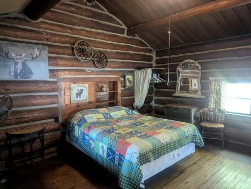 a bedroom with a bed in a log cabin at Secluded Cabin Rental with Fireplace on Moose Lake near Eau Claire, Wisconsin in New Post