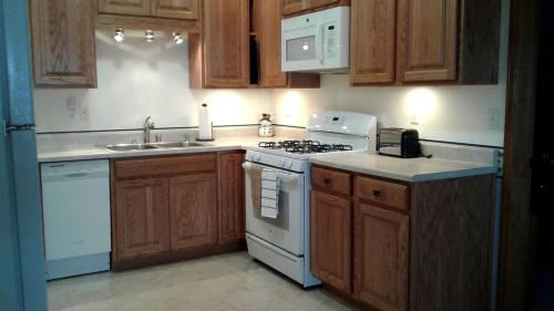 a kitchen with wooden cabinets and a white stove top oven at Family-Friendly Vacation Rental with Jaw-Dropping Views in Homer, Alaska in Millers Landing