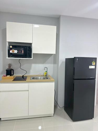 a kitchen with a black refrigerator and a sink at View Talay6 by Blue Ocean Suite in Pattaya Central