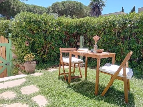 a wooden table and two chairs in a yard at Casa Vacanze Capalbio in Capalbio