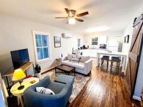 un salon avec un canapé et une cuisine dans l'établissement Picturesque Cozy Cottage with Fire Pit Space in Louisiana, à Pilette