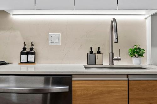 a kitchen with a sink and bottles of wine at Brookline LUX Apt Rooftop GameRoom Subway in Brookline