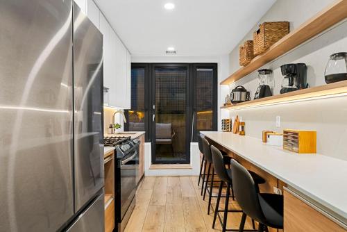 a kitchen with a long counter and some chairs at Brookline LUX Apt Rooftop GameRoom Subway in Brookline