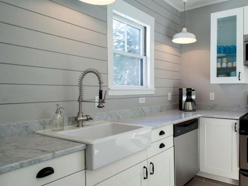 a white kitchen with a sink and a window at Modern Luxury Farmhouse with a Jacuzzi Tub near Woodstock, Vermont in Bridgewater