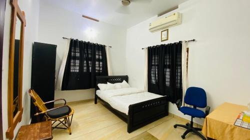 a bedroom with a bed and two chairs and a table at Green Island homestay in Kadalundi