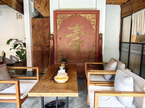 a room with a table and chairs and a door at Dali Xizhou Jiakedi 大理喜洲甲科第古宅文化民宿 in Dali