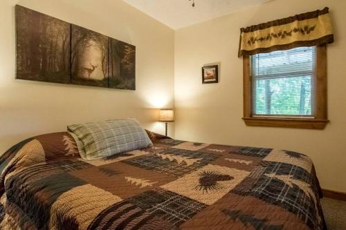 Un dormitorio con una cama con una colcha encima en Cabin in the woods w/ WIFI close to Monongahela National Forest, en Riverton
