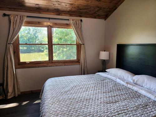 a bedroom with a large bed and a window at Gorgeous Secluded Wooden Cabin in Carbondale, Illinois in Etherton