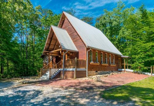 a large log cabin with a porch and a gambrel roof at Lovely Cabin with Hot-tub and Fireplace in Cleveland, Georgia in Kinseytown