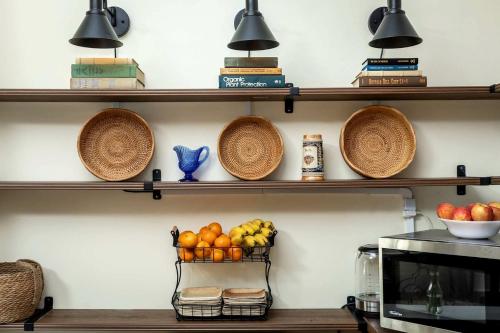 a kitchen with wooden shelves with fruits and baskets at Elegant Historic Suite with Mountain Views in Luray, Virginia in Luray