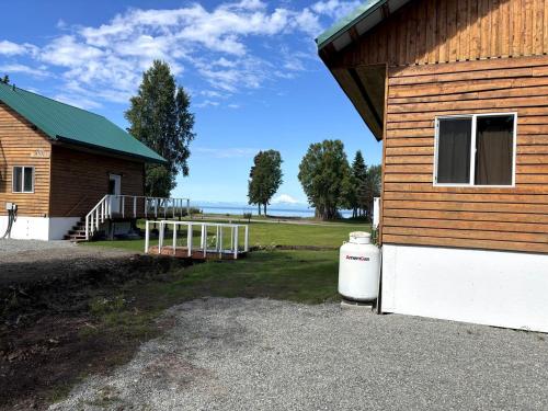 a building with a garage next to a house at Family-Friendly Cabin Rental Overlooking Cook Inlet in Alaska in Kasilof