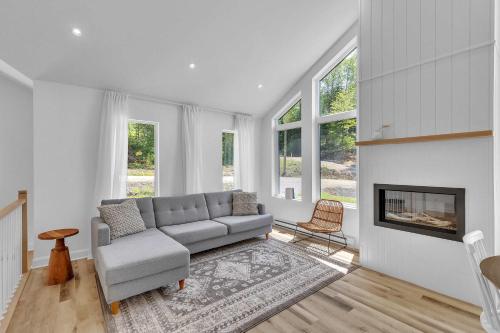 a living room with a couch and a fireplace at Spa & River - Le Zenith in Saint Come