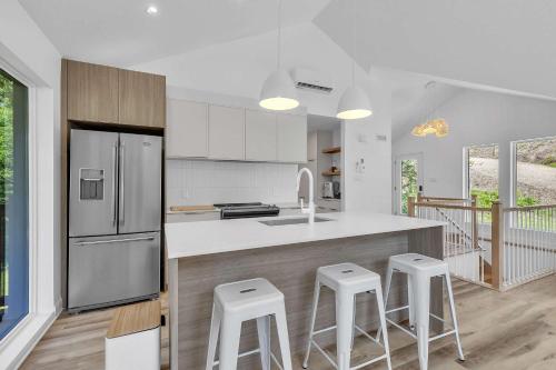 a kitchen with a counter and stools in it at Spa & River - Le Zenith in Saint Come