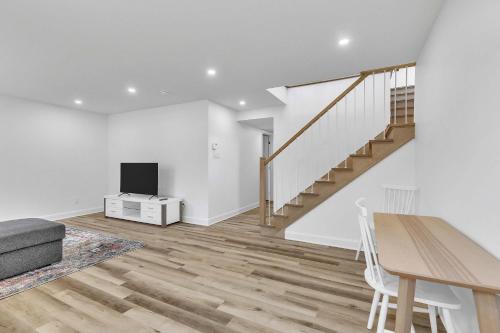 a living room with a staircase and a television at Spa & River - Le Zenith in Saint Come