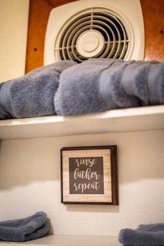 a room with a fan and a sign on a shelf at Quaint Cozy Cottage Perfect for a Peaceful Getaway in West Virginia in Pipestem