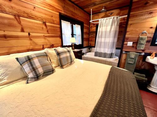 a bedroom with a bed in a wooden cabin at Romantic Ozarks Cabin Rental in Secluded Woodland near Branson, Missouri in Hollister