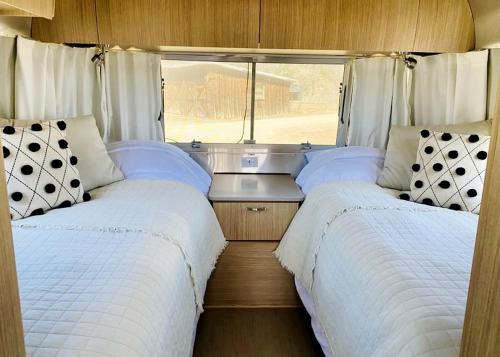 Un dormitorio con dos camas y una ventana. en Airstream in between Moab and Telluride, en Naturita