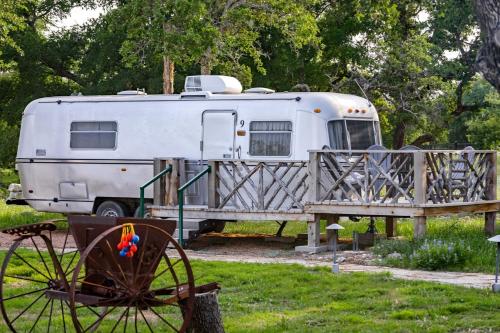 a white trailer parked next to a wooden fence at Fabulous Cozy Airstream Perfect for a Small Family Unique Escape in Texas in Spicewood