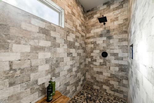 a bathroom with a brick wall and a window at Fabulous Cozy Airstream Perfect for a Small Family Unique Escape in Texas in Spicewood
