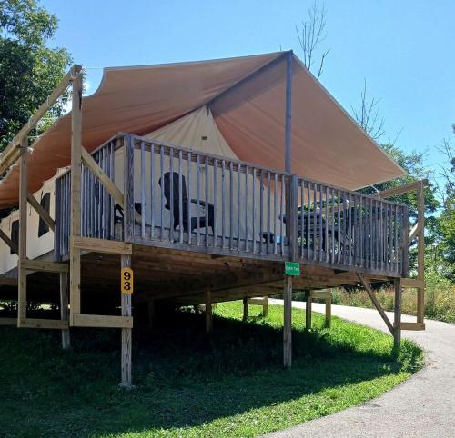 ローガンにあるSensational Tented Cabin Nestled Amidst Trees and Fire Pit Provided in Logan, Ohioの芝生の上にデッキがある大型テント