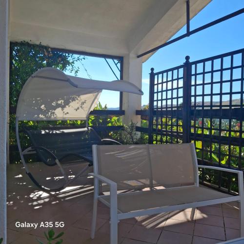 a chair on a porch with a view of a fence at Villetta immersa nel verde in Piazza Armerina