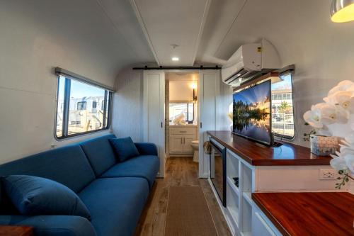 a living room with a blue couch in a caravan at Wagon Circle Unit in Prescott, AZ in Prescott