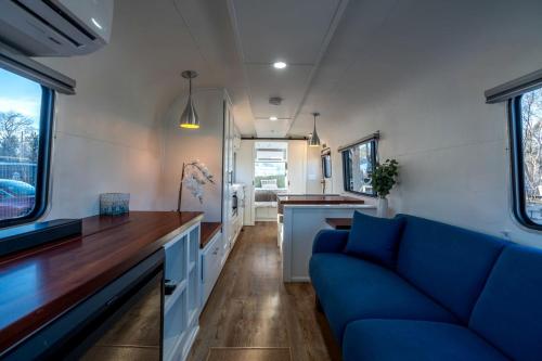 a living room with a blue couch in a tiny house at Wagon Circle Unit in Prescott, AZ in Prescott
