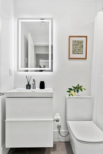 a white bathroom with a sink and a toilet at Brookline LUX Apt Rooftop GameRoom Subway in Brookline