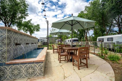 a table and chairs with an umbrella next to a pool at Wagon Circle Unit in Prescott, AZ in Prescott